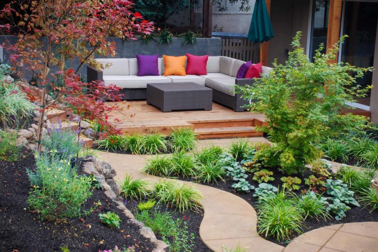 Scenic private garden and conversation area with colorful mix of plants and seating, with meandering walkways